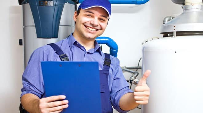 Smiling Technician Servicing An Hot Water Heater — Mannix Plumbing In QLD